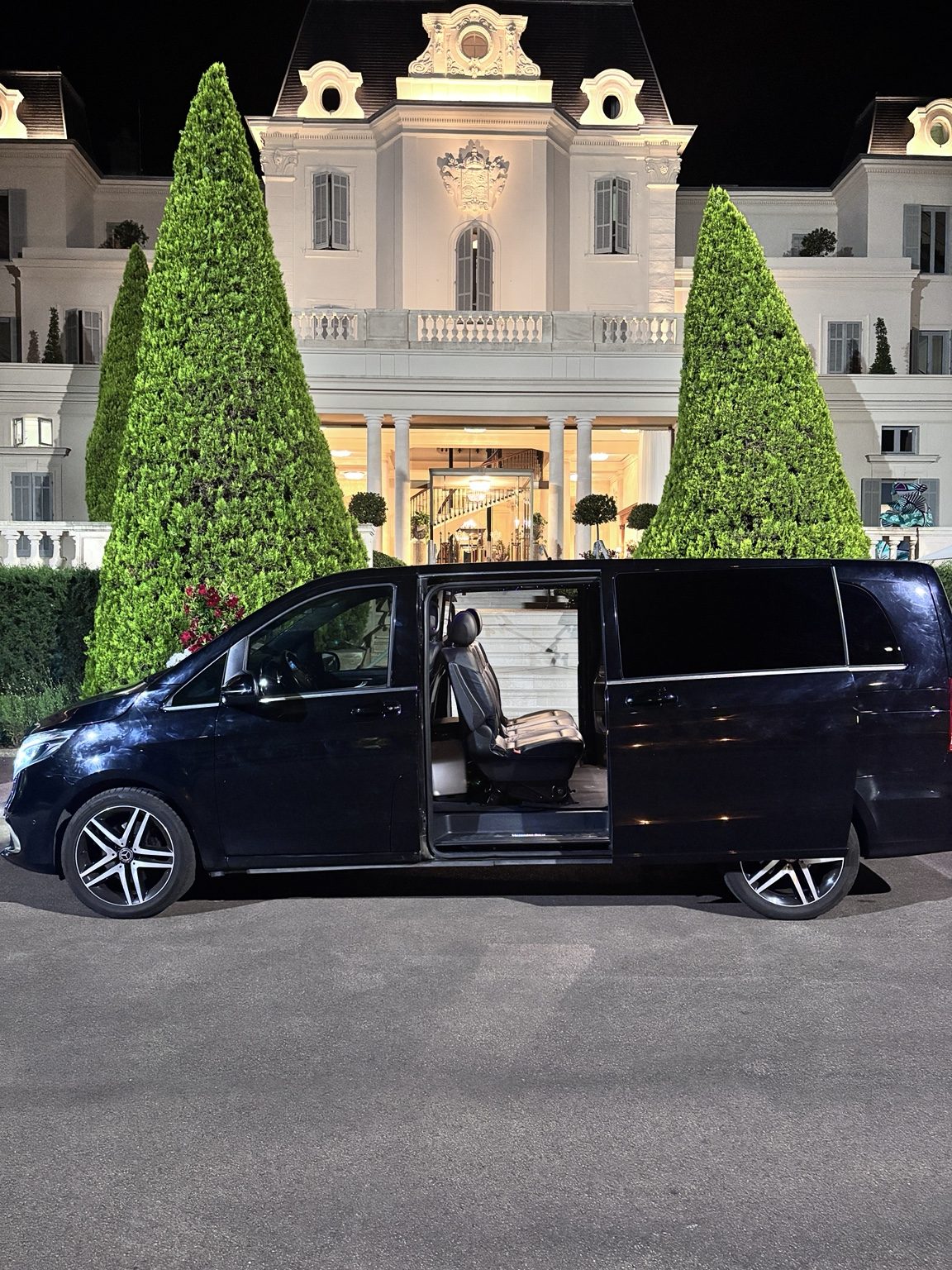 Chauffeur AMB Élite en costume sombre à côté d'une Mercedes noire — service VIP